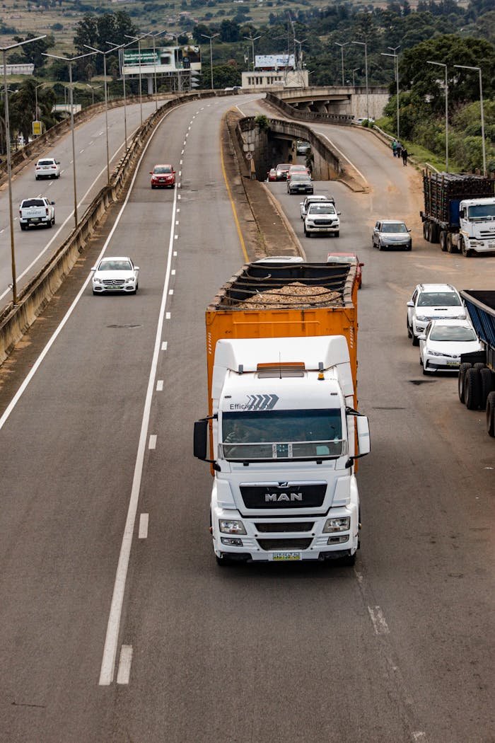 Aerial view of vehicles on a highway in Mbabane, Eswatini, featuring a large truck and multiple cars.